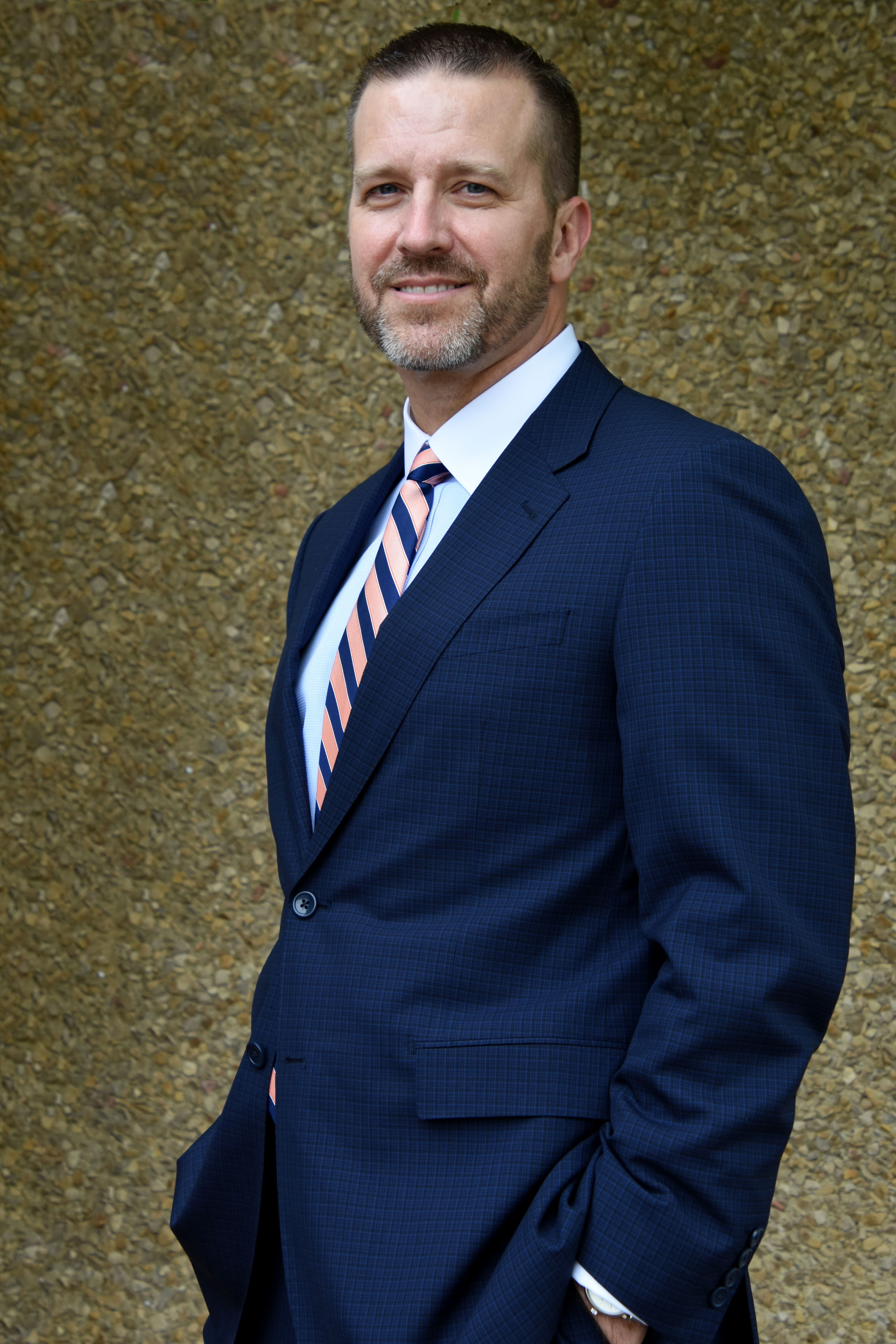 Brian J. Bagley, Founder & Chief Counsel, in a navy suit.